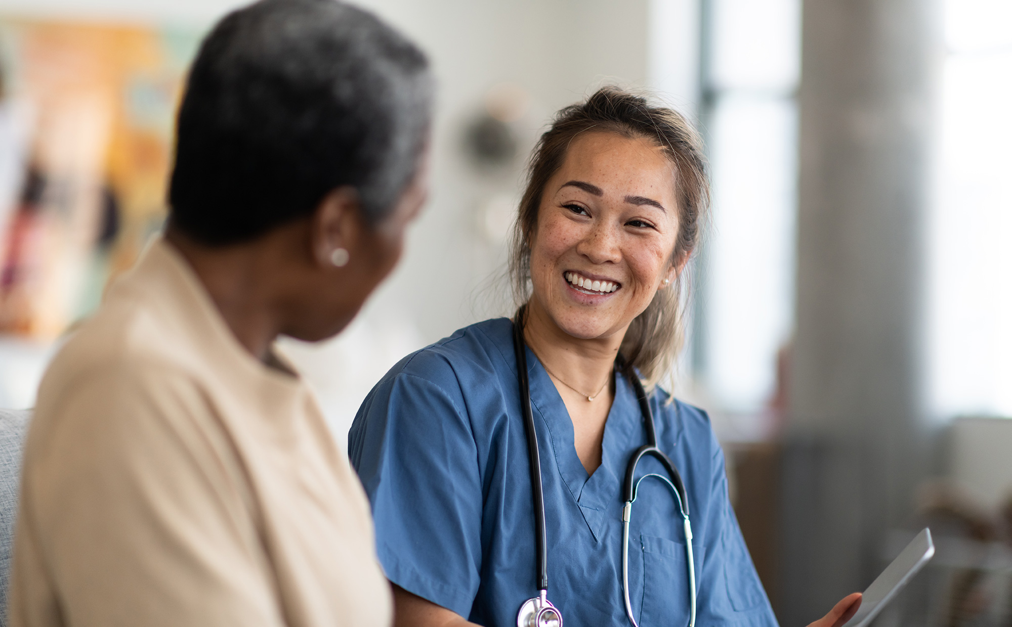 Female health professional sitting down, talking to patient